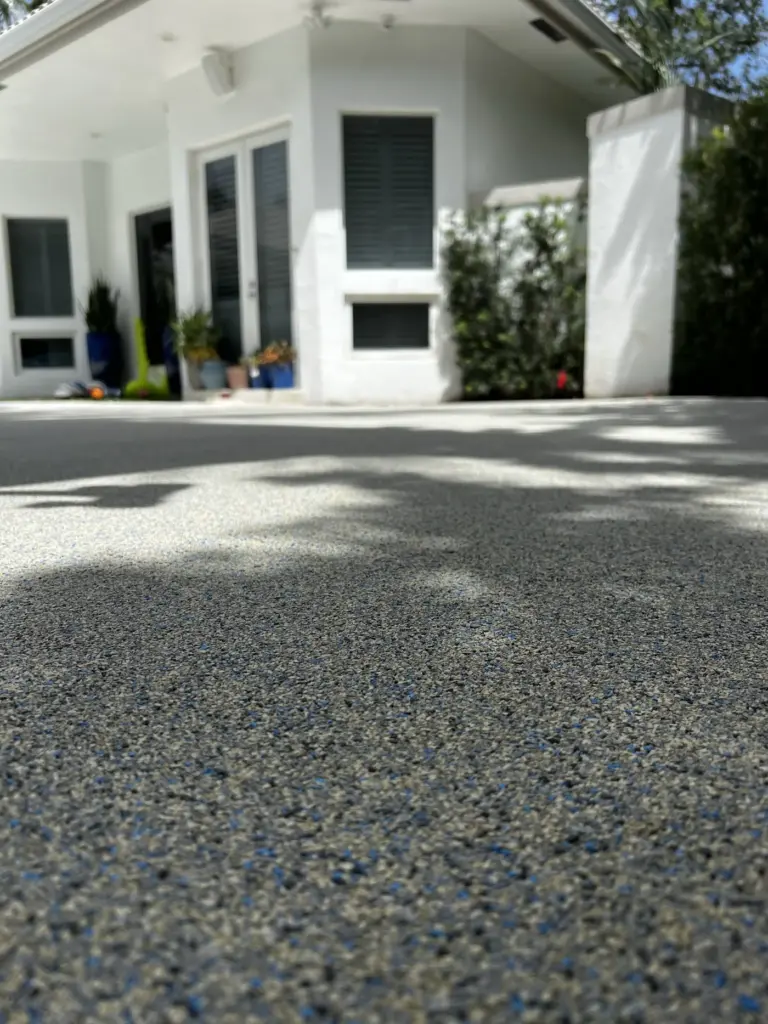 Grey speckled rubber surface leading to a white house entrance.