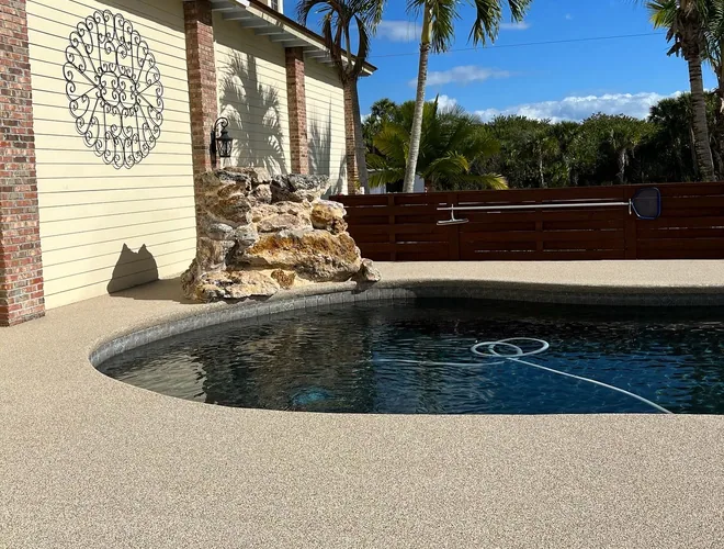Home pool and spa with a warm resurfaced deck and water feature