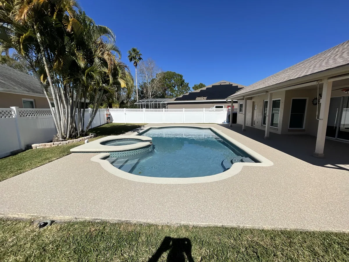 Backyard pool and spa surrounded by a warm resurfaced deck