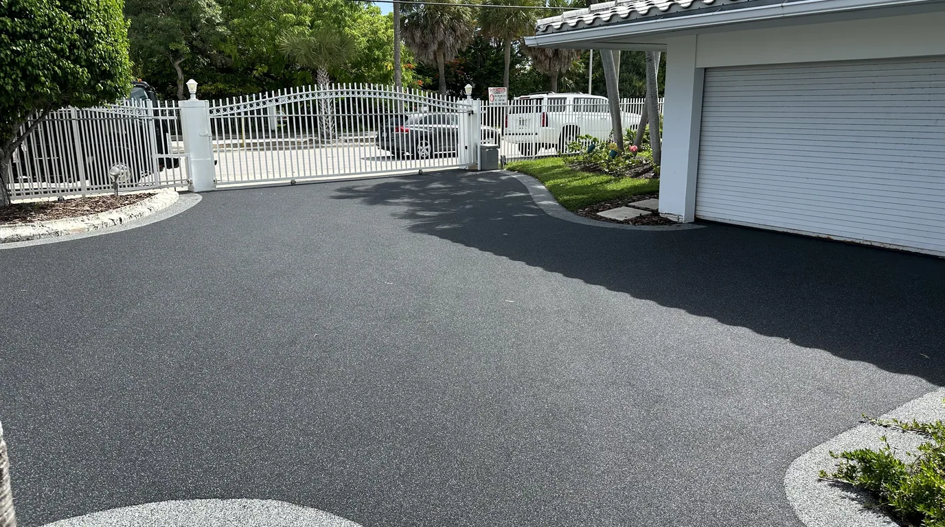 Resurfaced driveway sweeping up to a garage door, the kind of surface cleared with a snowblower in winter