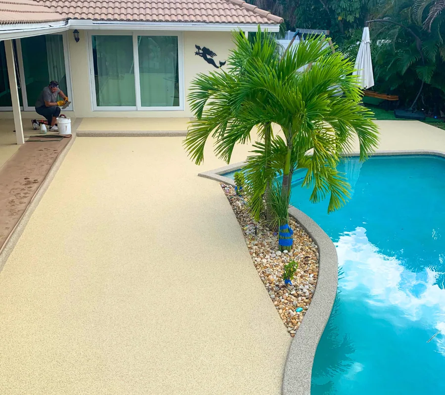 Pool patio after refinishing with a smooth sand-coloured rubber surface