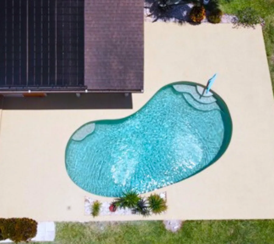 Aerial view of the same pool patio after resurfacing in a light sand tone