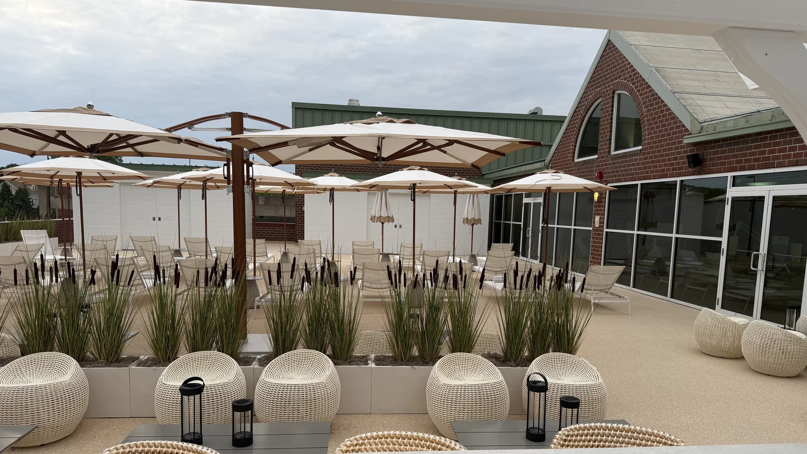 Natural marble stone surface on an outdoor terrace with umbrellas, planters and lounge seating.